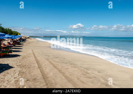 Longue ligne de parasols de plage sur la magnifique plage de Kuta à Bali calme Banque D'Images