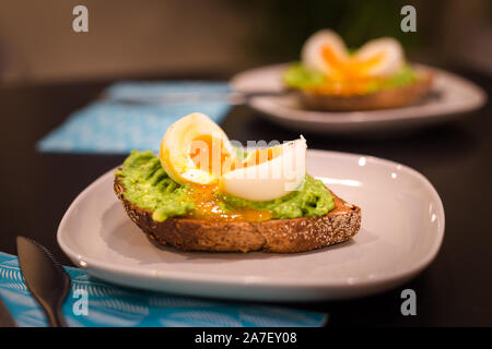 Deux assiettes avec un petit déjeuner sain d'avocat sur des toasts avec un œuf dur. Banque D'Images