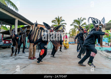 Cuajinicuilapa, au Mexique. 06Th Nov, 2019. Les jeunes avec des costumes de danse du diable en face d'une maison au cours de la danse traditionnelle de la Devils' dans le cadre de la 'Day of the Dead' un costume du diable. Comme chaque année, les villes de la Costa Chica de Guerrero, dans le sud du Mexique, célébrer les morts avec la danse héritée de leurs ancêtres d'origine africaine. La danse des Diables, chorégraphie avec laquelle ils sautent et stomp à travers les rues de Cuajinicuilapa et amener les âmes des morts dans les maisons de leurs proches. Credit : Jair Cabrera/dpa/Alamy Live News Banque D'Images