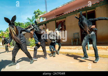 Cuajinicuilapa, au Mexique. 06Th Nov, 2019. Les jeunes avec des costumes de danse du diable en face d'une maison au cours de la danse traditionnelle de la Devils' dans le cadre de la 'Day of the Dead' un costume du diable. Comme chaque année, les villes de la Costa Chica de Guerrero, dans le sud du Mexique, célébrer les morts avec la danse héritée de leurs ancêtres d'origine africaine. La danse des Diables, chorégraphie avec laquelle ils sautent et stomp à travers les rues de Cuajinicuilapa et amener les âmes des morts dans les maisons de leurs proches. Credit : Jair Cabrera/dpa/Alamy Live News Banque D'Images