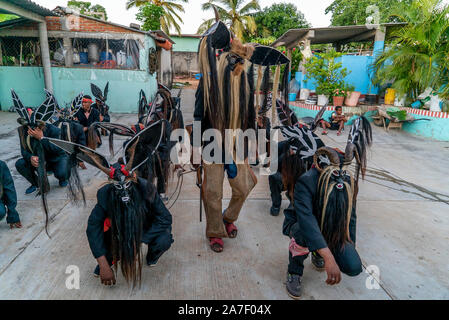 Cuajinicuilapa, au Mexique. 06Th Nov, 2019. Les jeunes avec des costumes de danse du diable en face d'une maison au cours de la danse traditionnelle de la Devils' dans le cadre de la 'Day of the Dead' un costume du diable. Comme chaque année, les villes de la Costa Chica de Guerrero, dans le sud du Mexique, célébrer les morts avec la danse héritée de leurs ancêtres d'origine africaine. La danse des Diables, chorégraphie avec laquelle ils sautent et stomp à travers les rues de Cuajinicuilapa et amener les âmes des morts dans les maisons de leurs proches. Credit : Jair Cabrera/dpa/Alamy Live News Banque D'Images