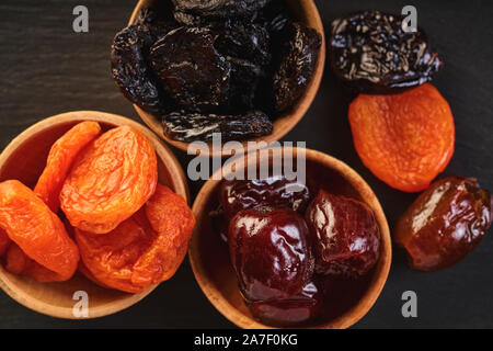 Un assortiment de fruits secs en bols en bois, vue du dessus Banque D'Images
