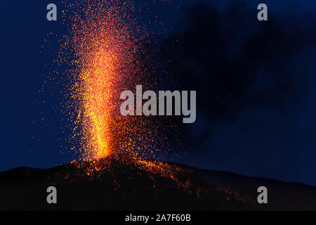 Éruption explosive au crépuscule dans l'un des trois cratères du volcan Stromboli actif, îles éoliennes, Italie. Banque D'Images