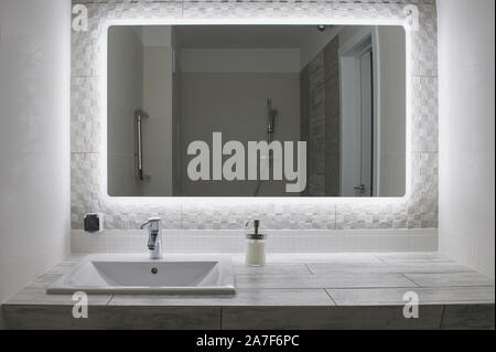 Nettoyage confortable salle de bains moderne avec grand miroir et appuyez sur Banque D'Images