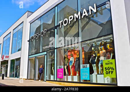 L'élévation de la façade moderne Topshop et Topman boutiques dans le centre Quedam Yeovil. Mesdames et détaillant de mode de mens. Jeune femme entrant dans un magasin à l'autre. Banque D'Images