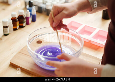 Mains de fille créative mélangeant couleur lavande avec du savon liquide en masse verrerie Banque D'Images