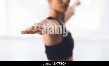 Woman exercising yoga Yoga à warrior pose, focus on hand Banque D'Images