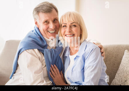 Senior couple embracing and smiling to camera Banque D'Images