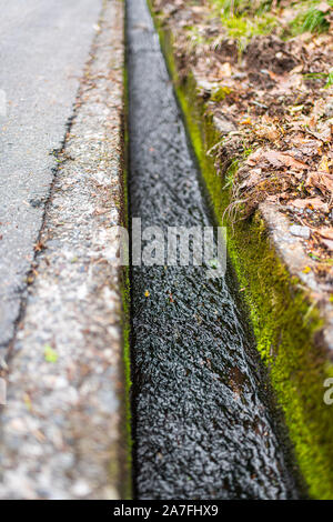 Petit cours d'eau des gouttières le long de la route dans les villages Okuhida dans la préfecture de Gifu, Japon park avec de l'eau découlant de la fonte des neiges Banque D'Images