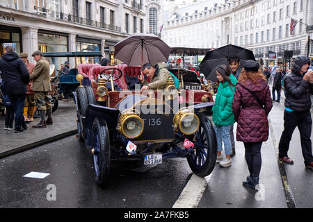 Westminster, England, UK. 2 novembre 2019.Le Regent Street Motor Show, un événement qui met en vedette 125 ans de l'automobile véhicule qui a eu lieu aujourd'hui sur l'image. L'événement disposent d'un grand nombre de véhicules et participant de la course de voiture à Bonham se tiendra demain à partir de Londres. Visiteurs bravant la pluie inspection vintage car. Credit : JF Pelletier/Alamy Live News. Banque D'Images