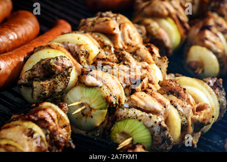 Brochettes marinées (brochette de viande) avec saucisses grillés sur un barbecue sur charbon de bois en gros plan Banque D'Images