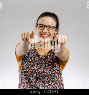 Happy woman smiling et pointant vers l'appareil photo Banque D'Images