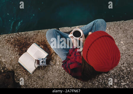 Belle femme profitant de son jour dans le lac avec une tasse de café chaud Banque D'Images