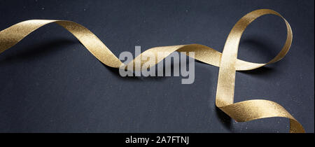 Or, ruban de Noël ruban brillant sur fond noir, décoration de Noël, cadeaux concept, bannière, Banque D'Images