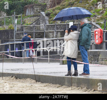 Lyme Regis, Dorset, Royaume-Uni. 2 novembre 2019. Météo au Royaume-Uni : les visiteurs photographient ce qui reste de la plage. Une grande zone de Lyme Redis jolie plage de sable est cordoned après que le sable a été lavé pendant la lourde nuit de pluie crédit: DWR / Alamy Live News. Banque D'Images