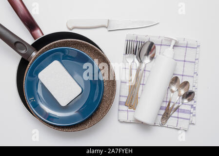 Vaisselle, blanc bouteille de détergent, les éponges et les serviettes sur la télévision blanc fond laïcs. Lave-up concept. Banque D'Images