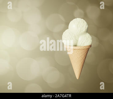 Boules délicieux très détaillées de la glace à la vanille dans un cornet gaufré Résumé arrière-plan coloré. Bokeh bulles. Banque D'Images