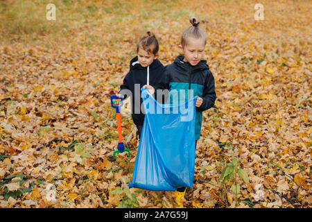 Petit frère et soeur à la recherche d'une poubelle dans une forêt à l'automne Banque D'Images