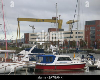 Bateaux dans la marina au quartier Titanic Belfast avec rencontré derrière et l'emblématique H&W grues jaunes à l'arrière-plan. Banque D'Images