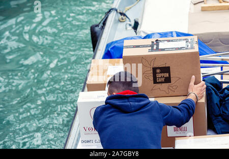 Venise, Italie - 20 mars, 2015:vue arrière de l'homme livraison déménagement cartons café moderne à l'intérieur bateau sur canal in Venice Banque D'Images
