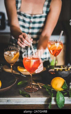 Jeune femme le mélange des ingrédients à l'Aperol spritz verre Banque D'Images