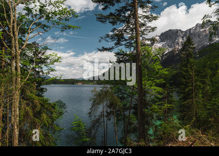 Le lac Eibsee bavarois au pied du Zugspitze couverte de neige avec de l'eau azur clair, ciel bleu et nuages blancs en été (Berlin, Allemagne, Europe) Banque D'Images