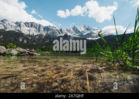 Le lac Eibsee bavarois au pied du Zugspitze couverte de neige avec de l'eau azur clair, ciel bleu et nuages blancs en été (Berlin, Allemagne, Europe) Banque D'Images