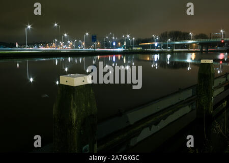Petit port et pont près de Gouda, aux Pays-Bas. Belles réflexions de l'éclairage de rue dans l'eau calme d'un canal. Banque D'Images