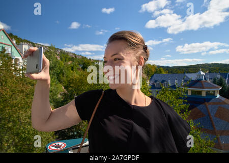 La station Mont-Tremblant, femme fait les touristes avec selfies téléphone sur un funiculaire au Québec Canada. Banque D'Images