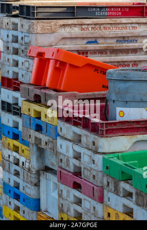 Piles et piles de caisses de pêche en plastique colorées multicolores et de conteneurs de stockage sur le quai des puits près de la mer dans le nord de norfolk, au royaume-uni. Banque D'Images