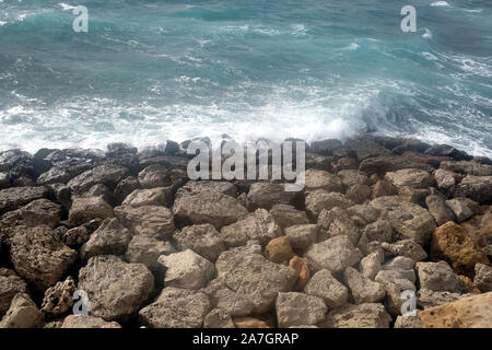 Paysage avec des vagues se brisant sur la mer des grandes pierres côtières aux beaux jours d'été Banque D'Images