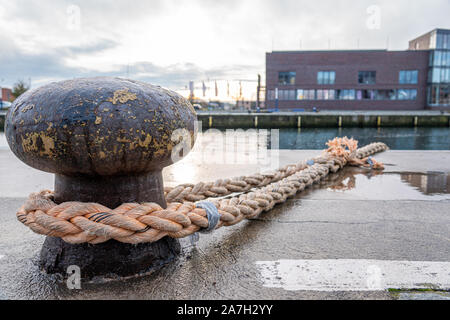 Un navire est attaché avec une corde épaisse d'un bollard dans le port Banque D'Images