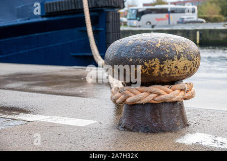 Un navire est attaché avec une corde épaisse d'un bollard dans le port Banque D'Images