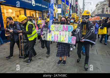 Londres, Royaume-Uni. 2 novembre 2019. Presque tous les manifestants vêtus de noir et beaucoup avec des masques noirs mars le long de la chaussée de la rue Oxford appelant à Hong Kong d'être libre et de faire cinq exigences. Ils veulent un retrait complet de la Loi sur l'extradition, une rétractation de caractériser les manifestations que les émeutes, le retrait des poursuites contre les manifestants, une enquête indépendante sur la brutalité policière et la mise en œuvre de la double le suffrage universel.Peter Marshall/Alamy Live News Banque D'Images