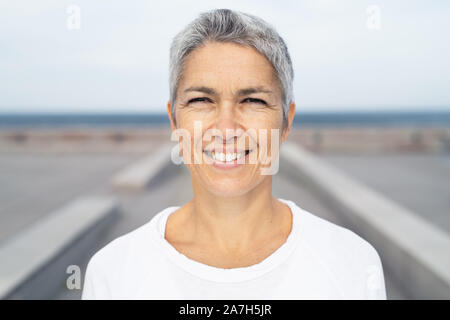 Portrait of a smiling middle-aged woman à l'océan Banque D'Images