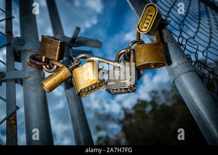 Cinq écluses sur grillage gate avec blur ciel et fond de nuage Banque D'Images