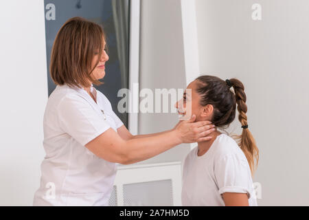 Femme médecin contrôle de la bouche d'une adolescente avec un dépresseur du. Banque D'Images