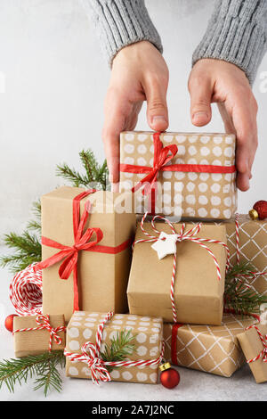 La prise de main d'hommes d'un cadeau d'une grande pile de cadeaux. Préparation de Noël. Banque D'Images
