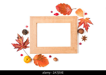 Cadre photo blanc avec des feuilles d'automne, Coing, noix et baies sur fond blanc. Jour de Thanksgiving concept. Télévision. Vue de dessus Banque D'Images