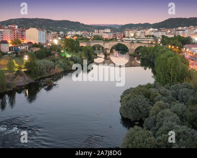 Temps-image superposée de le pont romain sur le fleuve Miño au coucher du soleil, vu depuis le Millenium bridge, à Ourense, Galice, Espagne Banque D'Images