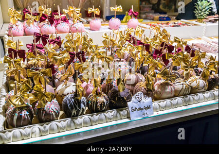 Hambourg, Allemagne - 14 décembre 2018 : Kiosque sur le marché de Noël avec des bonbons Chocolat Apfel - chocolat décoré avec des noix, pommes Banque D'Images