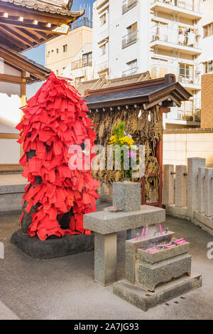Statue de la déité bouddhiste Akagami Nio couverte de papiers rouges déposées par les fidèles de purifier et de guérir les malades certaines parties de leur corps dans le Japa Banque D'Images