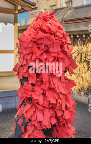 Statue de la déité bouddhiste Akagami Nio couverte de papiers rouges déposées par les fidèles de purifier et de guérir les malades certaines parties de leur corps dans le Japa Banque D'Images