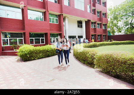 Un deux jeunes étudiants du Collège des amis Lire Livre Sudying In-Outside ensemble l'éducation Campus Building Banque D'Images