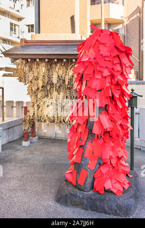 Statue de la déité bouddhiste Akagami Nio couverte de papiers rouges déposées par les fidèles de purifier et de guérir les malades certaines parties de leur corps dans le Japa Banque D'Images