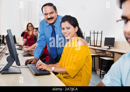 Aider les enseignants de l'ordinateur Étudiant College Girl avec l'éducation à l'étude de leçon d'informatique Computer Class Banque D'Images