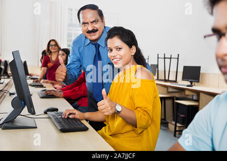 Young-Woman avec le professeur Étudiant Étudiant et Showing Thumbs-up at Computer Class Banque D'Images