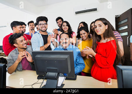 Professeur de collège avec les élèves qui étudient l'éducation informatique At-Classroom Clapping-Hands Célébrons les succès Banque D'Images