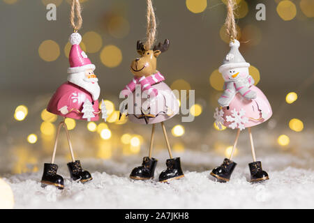 Figurines décoratives d'un thème de Noël. Ensemble de statuettes de santa, bonhomme de neige et les cerfs. Décoration d'arbre de Noël. Décor de fête, chaud bokeh lights Banque D'Images