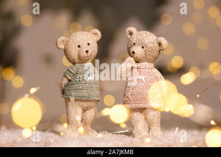 Figurines décoratives d'un thème de Noël. Univers miniatures d'adorables nounours d'un garçon et une fille dans les chandails avec des daims. Décor de fête, chaud bokeh lights Banque D'Images